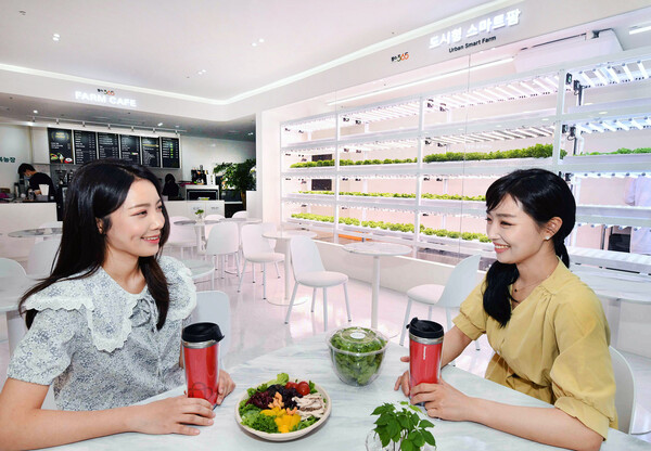 모델들이 홈플러스 서울 성산동 월드컵점에 오픈한 스마트팜 카페에서 재배한 작물로 완성된 샐러드와 음료를 마시고 있다. [사진=홈플러스]