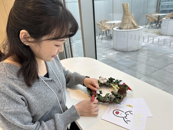   지난해 12월, 한국타이어 직원이 소외계층 아동들을 위한 재능 기부 봉사활동인 ‘크리스마스 리스 만들기’ 행사에 참여하고 있다. [사진=한국타이어]